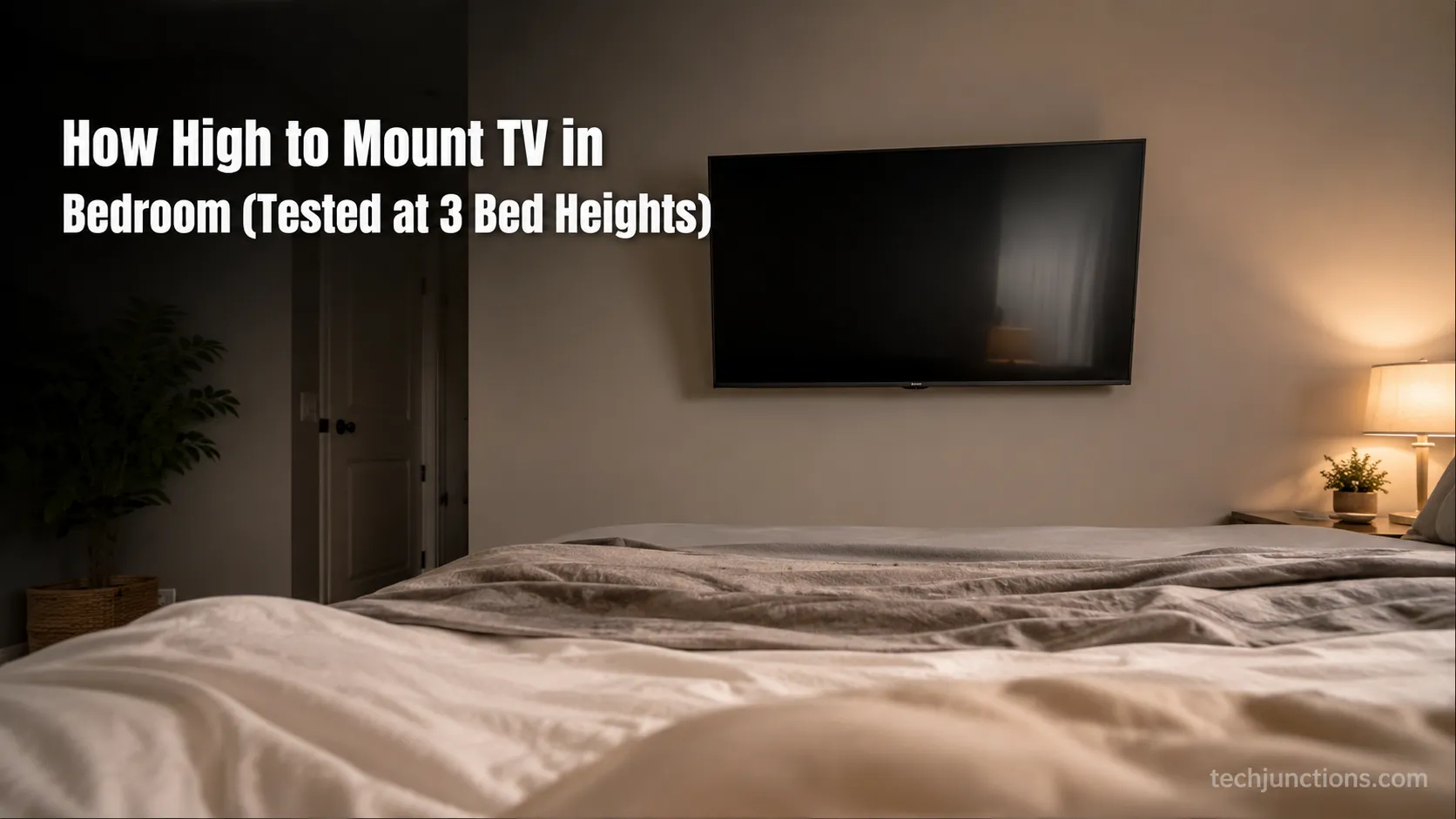 Wall-mounted bedroom TV tilted down toward a made bed, viewed from the foot of the bed.