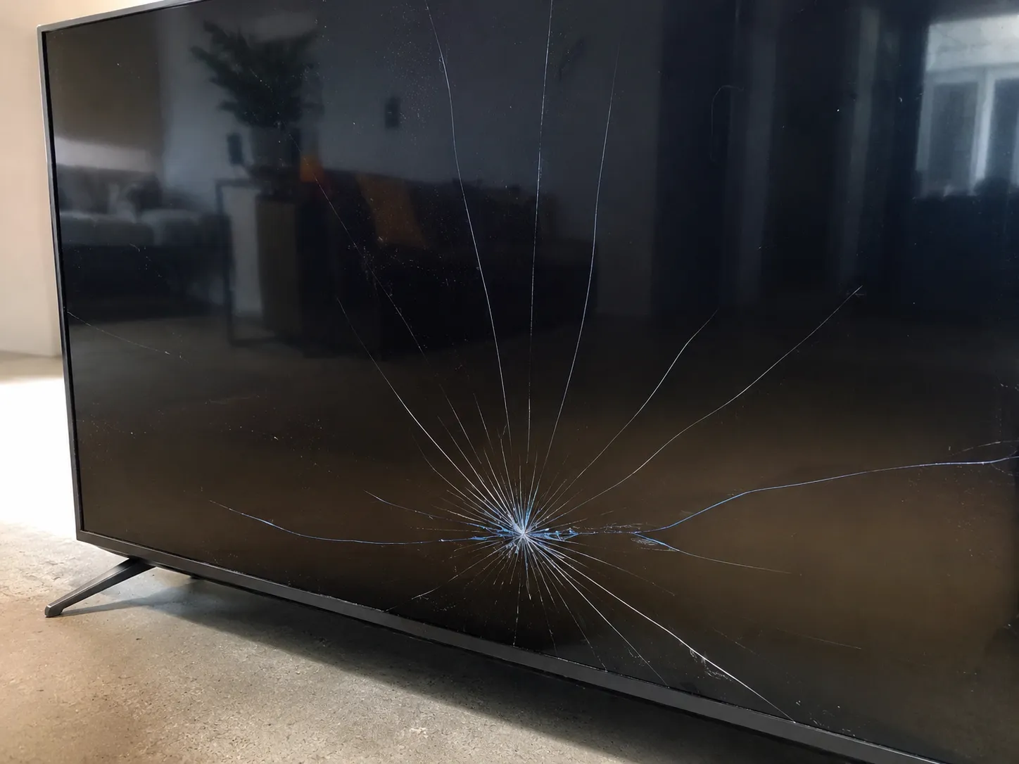 Cracked TV panel with a star-shaped fracture a Geek Squad agent called a total loss