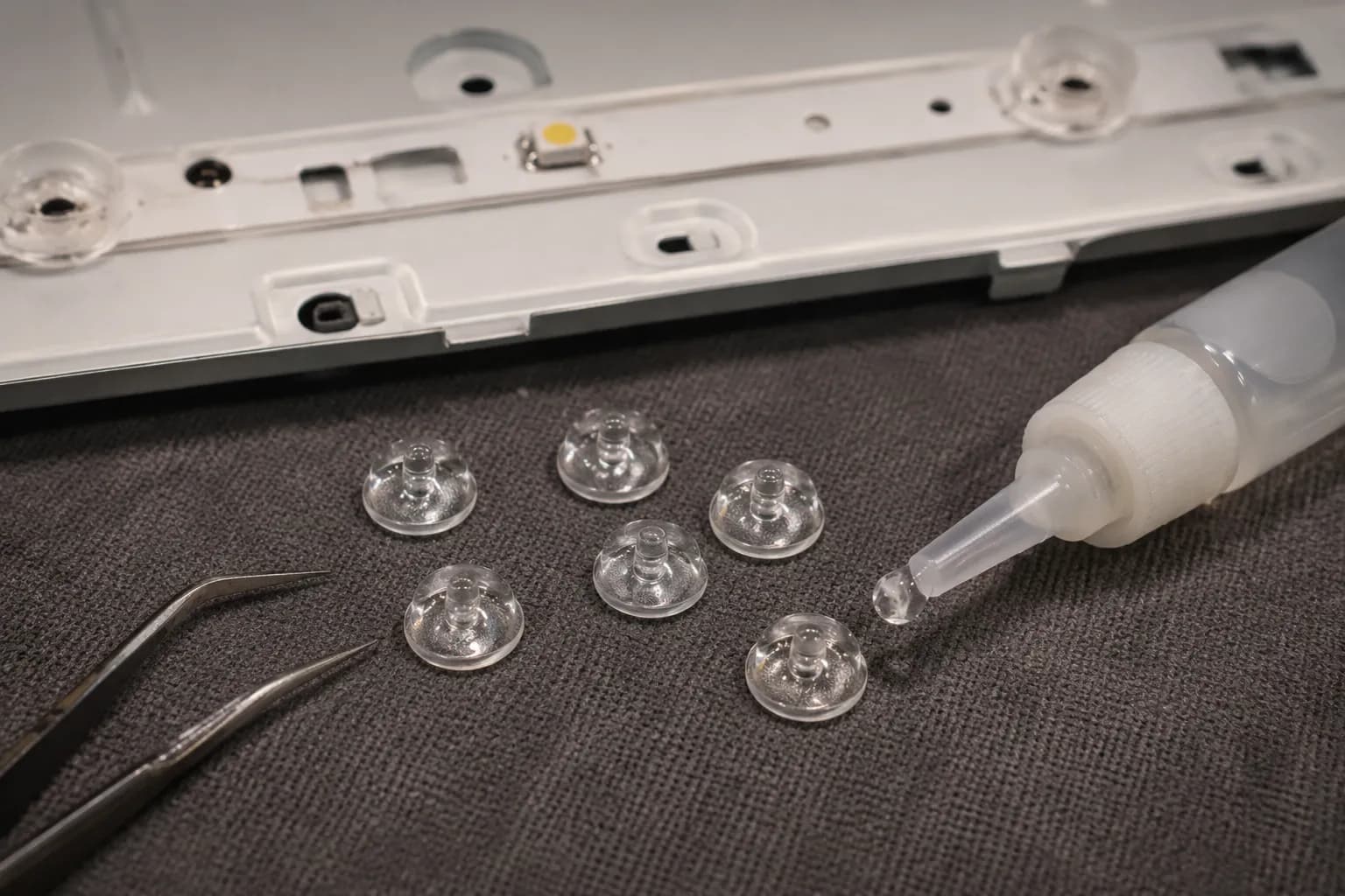 Fallen TV backlight diffuser lenses on a bench ready for regluing.