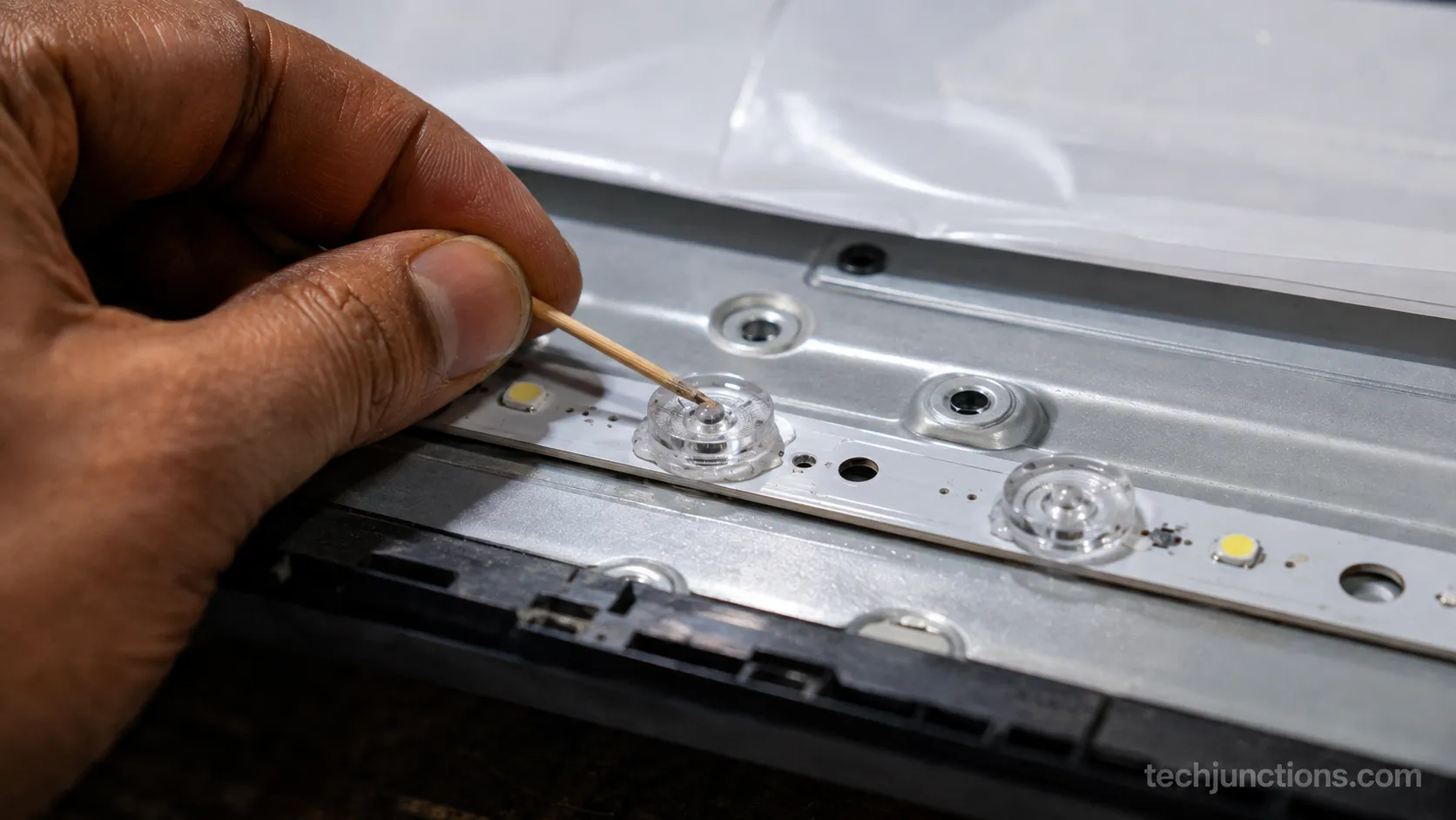 Regluing a fallen LG TV backlight lens onto the LED strip.