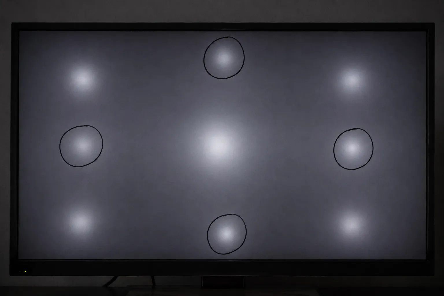 TV screen showing circular bright spots caused by fallen diffuser lenses.