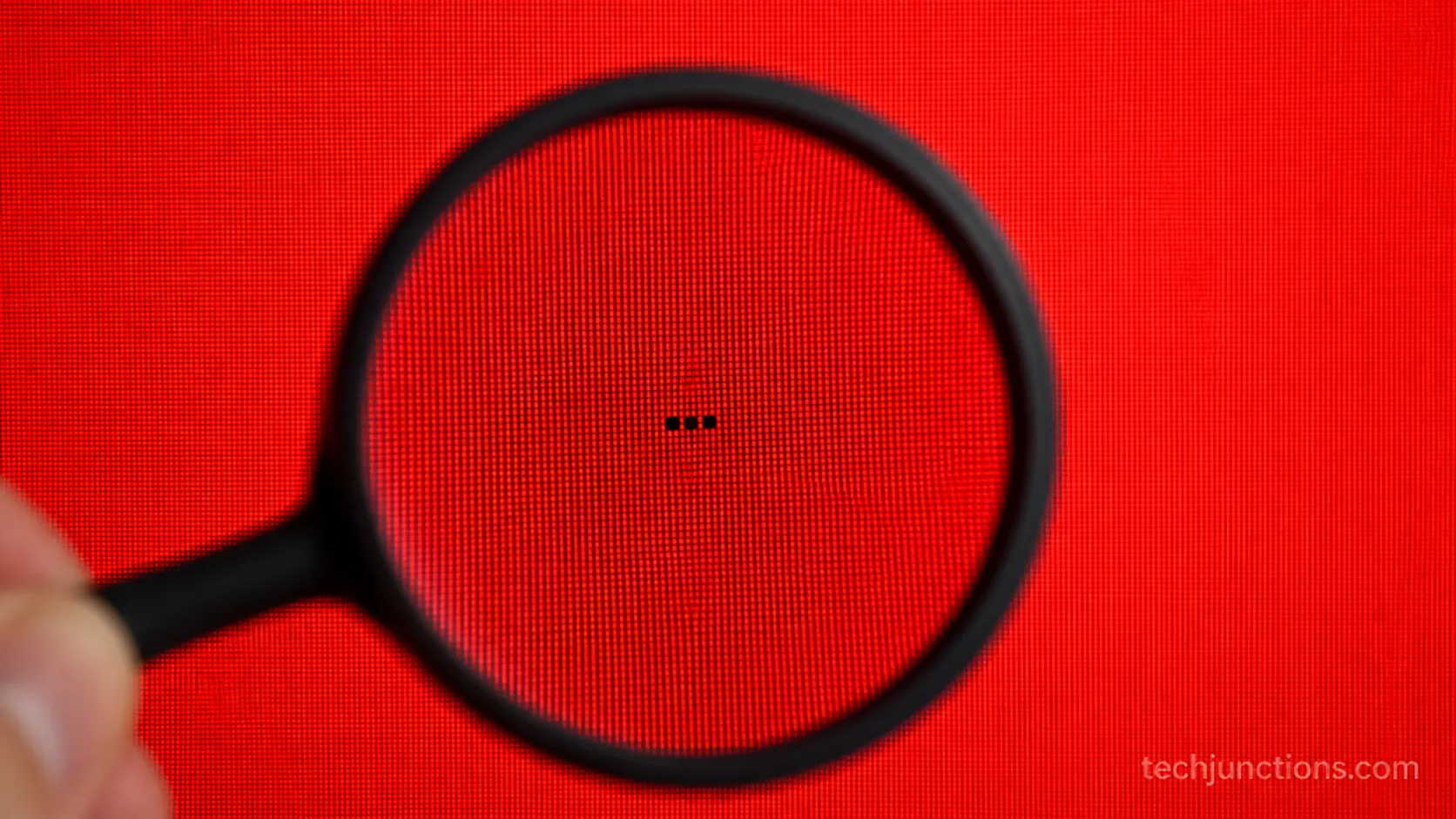 Solid red test screen revealing a small cluster of dead pixels on a TV