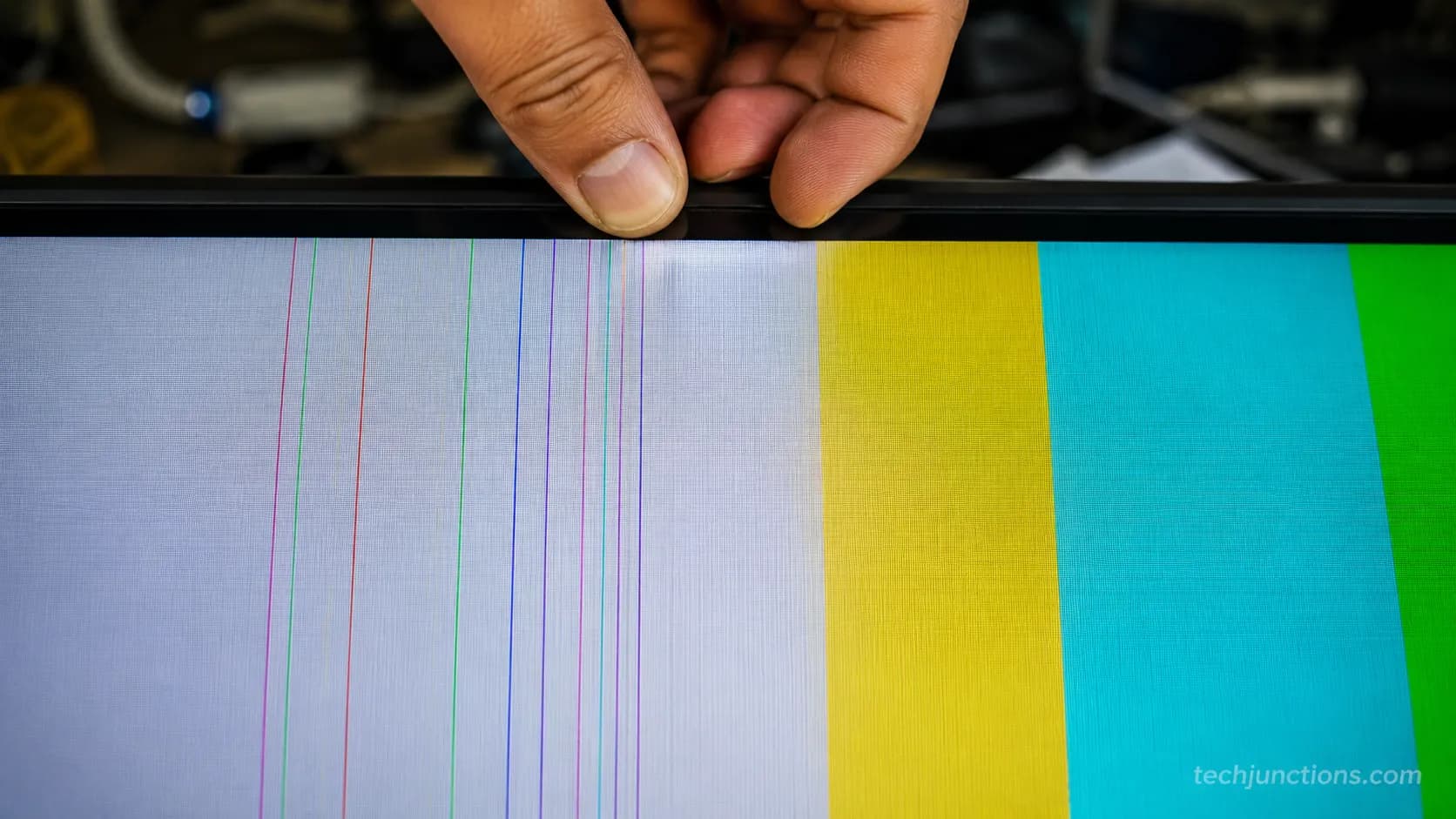 Vertical colored lines on a TV shifting as a hand presses the frame edge