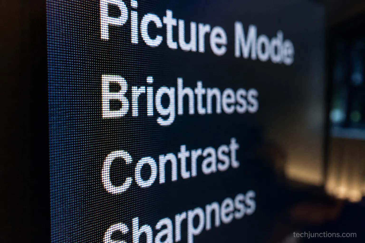 Macro close-up of on-screen text on a 4K TV showing faint pixel edges at a very short viewing distance.
